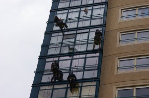 Abseilende mannen bungelen aan de Sequoia, een hoog flatgebouw